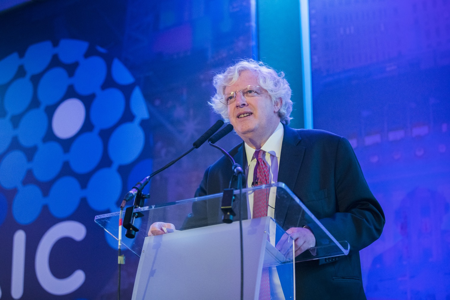 Guy Hands, founder of Terra Firma, speaking at a lectern at the 2019 Alternative Investments Conference.