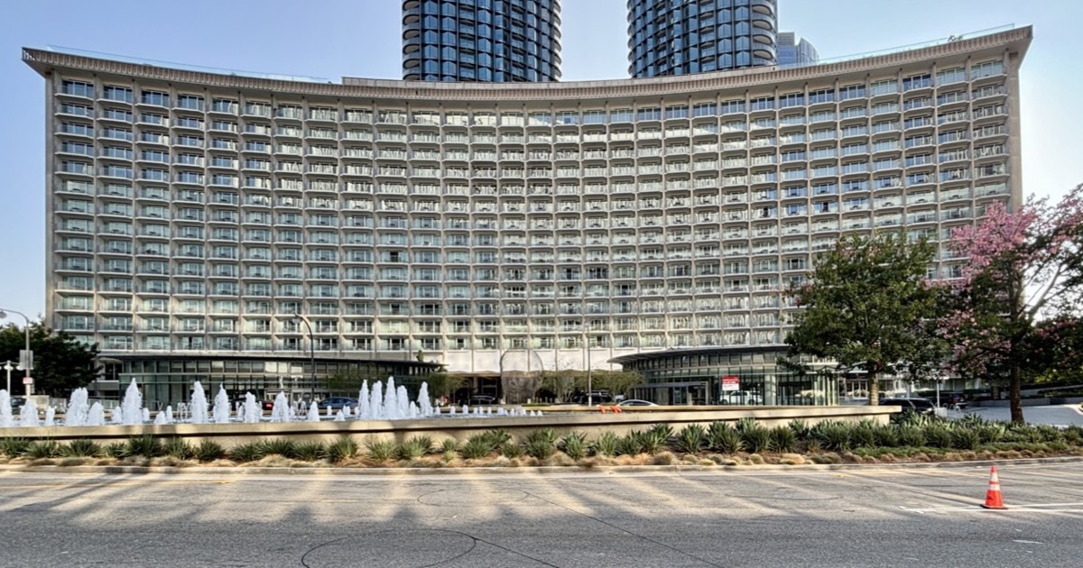 The Fairmont Century Plaza’s preserved crescent facade with fountains in front and the two Park Elm towers rising directly behind it.
