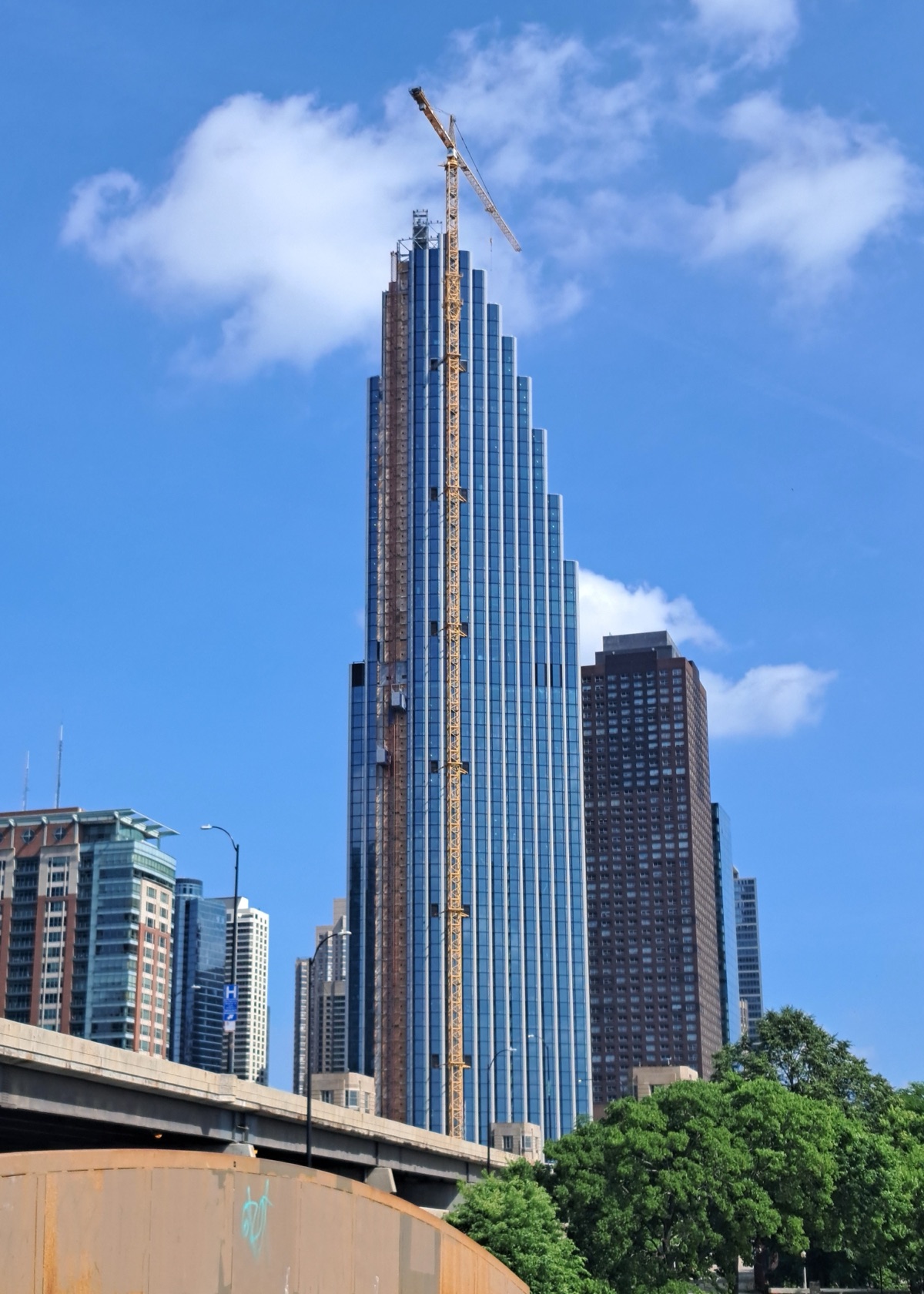 400 Lake Shore in June 2026 — the 72-storey stepped tower nearly topped out on the old Spire site, its glass curtain wall following the setbacks.