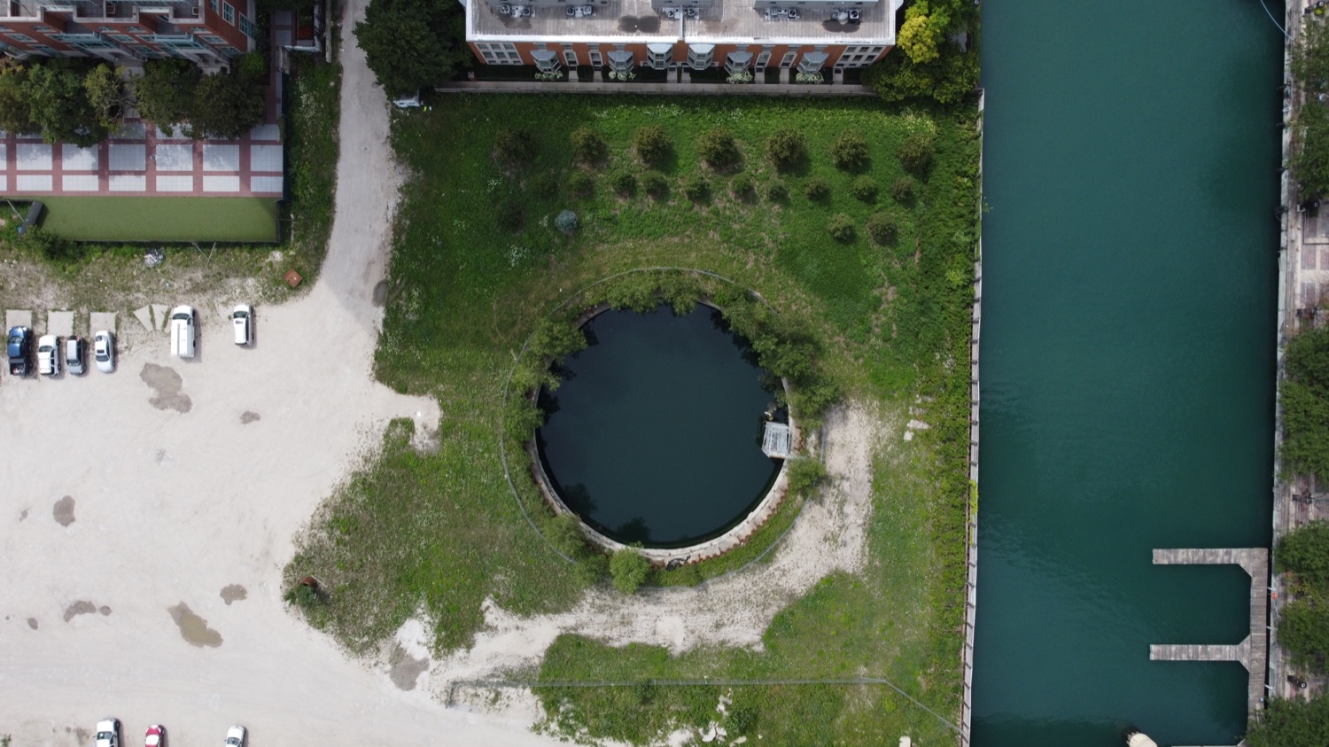 The Chicago Spire foundation hole in 2021 — the weathered circular cofferdam behind fencing on the empty gravel site, thirteen years after work stopped.