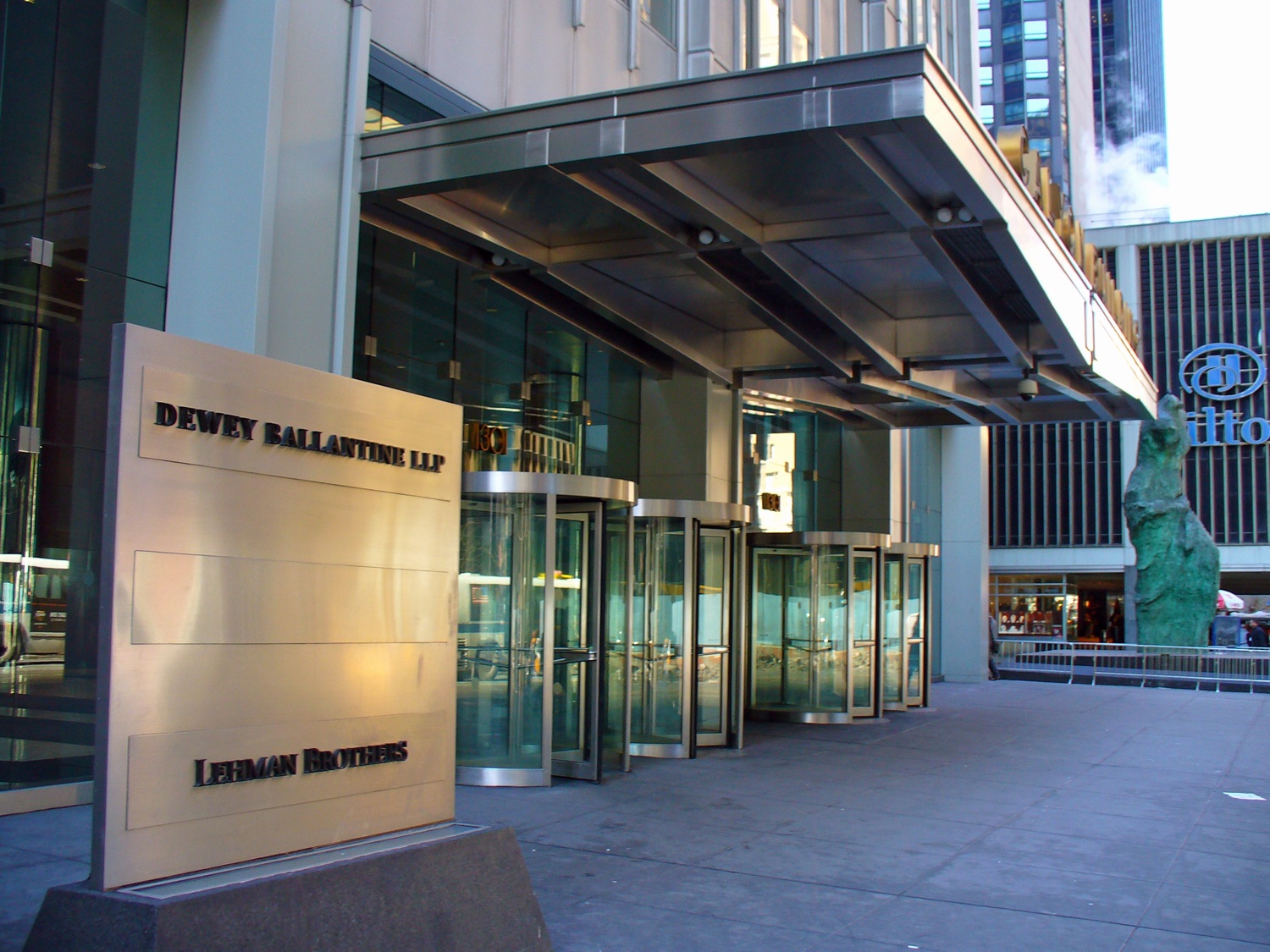 The entrance of 1301 Avenue of the Americas in February 2007 — steel canopy over revolving doors, with a brass sign listing Dewey Ballantine LLP and Lehman Brothers as tenants.