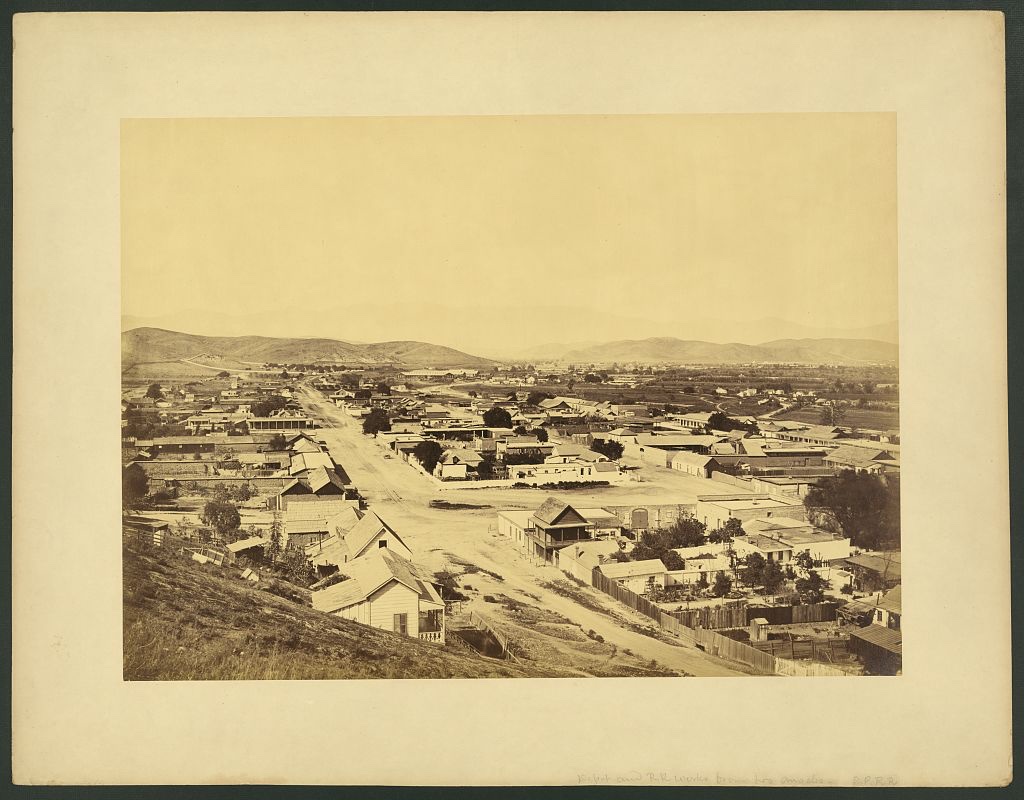The Southern Pacific Railroad depot and works in Los Angeles in 1877 — long sheds and rail yards on open ground, in an albumen photograph attributed to Carleton Watkins.