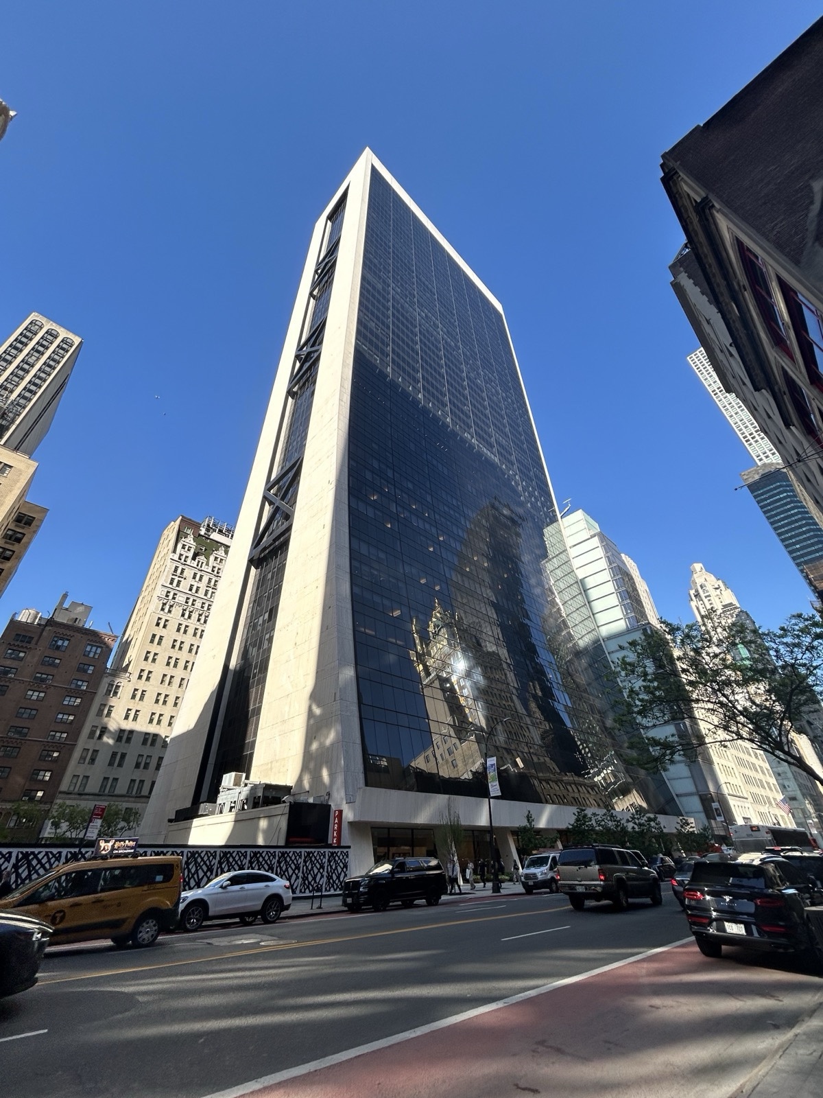 The Solow Building at 9 West 57th Street, Manhattan — the sloped black-glass tower where Apollo Global Management has its headquarters — photographed from street level in May 2024.