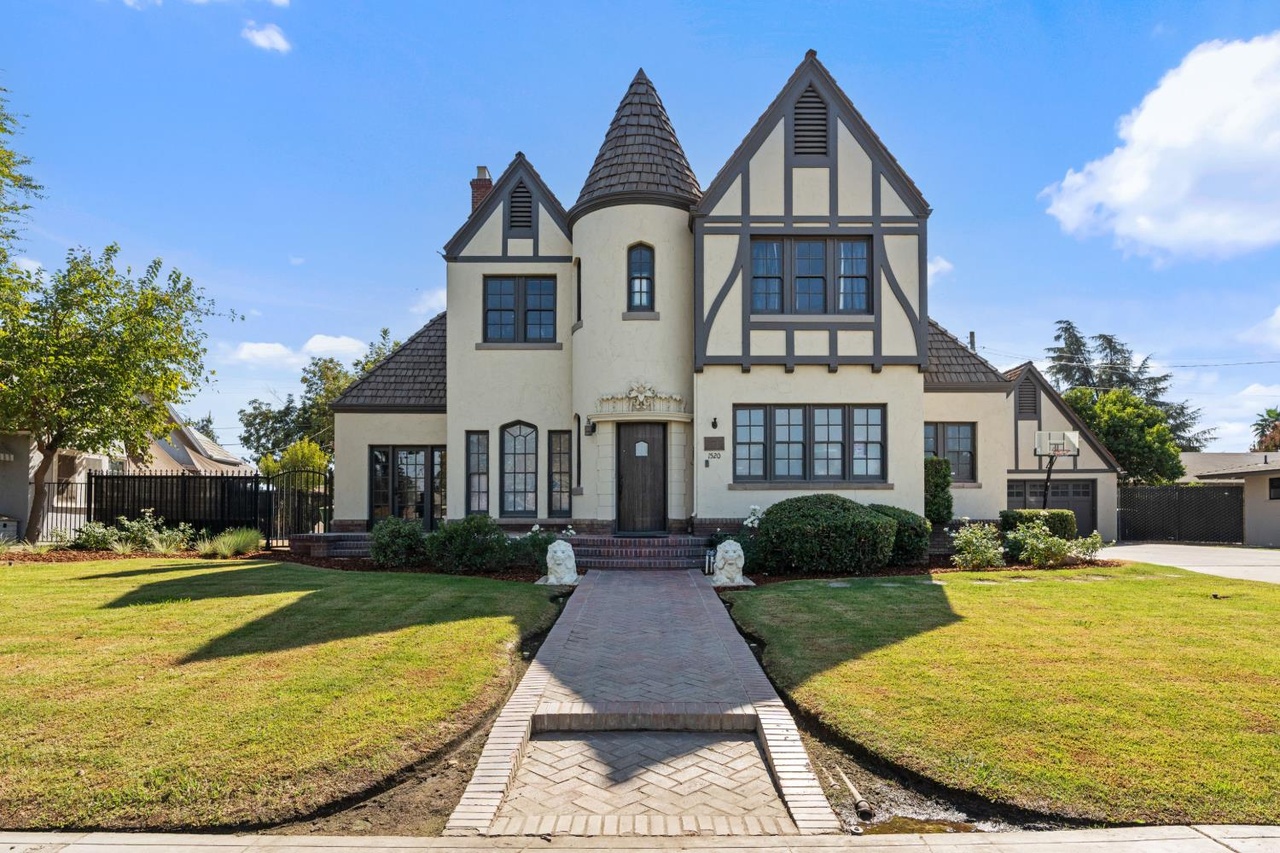 The turret, steep roofs and front lawn of the Paul Kindler House at 1520 East Olive Avenue.